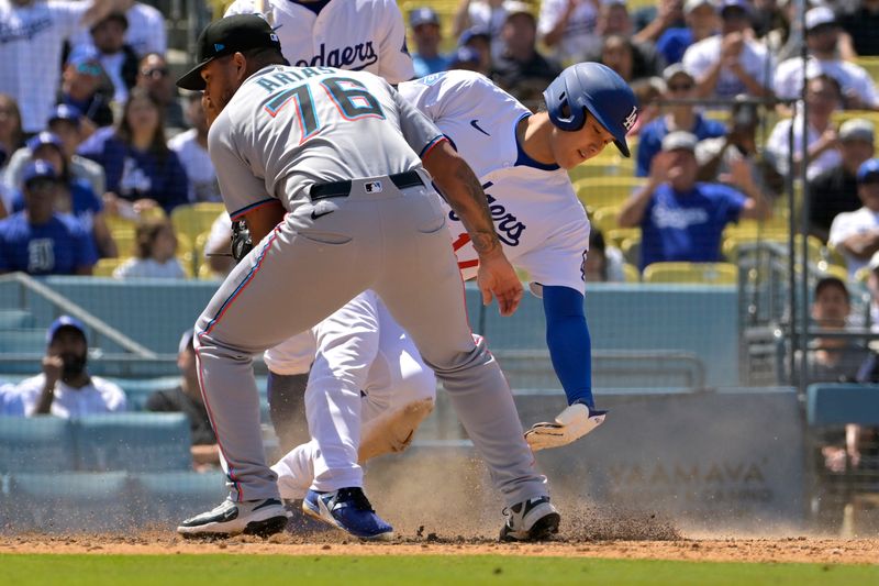 Apr 30, 2025; Los Angeles, California, USA;  Los Angeles Dodgers designated hitter Shohei Ohtani (17) beats the tag by Miami Marlins relief pitcher Luarbert Arias (76) scoring on a wild pitch in the eighth inning at Dodger Stadium. Mandatory Credit: Jayne Kamin-Oncea-Imagn Images