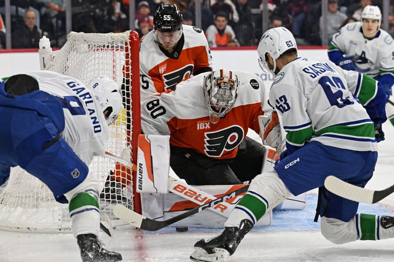 Dec 22, 2025; Philadelphia, Pennsylvania, USA; Philadelphia Flyers goaltender Dan Vladar (80) makes a save against Vancouver Canucks right wing Conor Garland (8) and center Max Sasson (63) during the third period at Xfinity Mobile Arena. Mandatory Credit: Eric Hartline-Imagn Images
