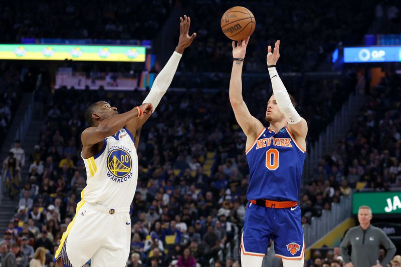 SAN FRANCISCO, CALIFORNIA - MARCH 18: Donte DiVincenzo #0 of the New York Knicks shoots over Jonathan Kuminga #00 of the Golden State Warriors in the first half at Chase Center on March 18, 2024 in San Francisco, California. NOTE TO USER: User expressly acknowledges and agrees that, by downloading and or using this photograph, User is consenting to the terms and conditions of the Getty Images License Agreement.  (Photo by Ezra Shaw/Getty Images)