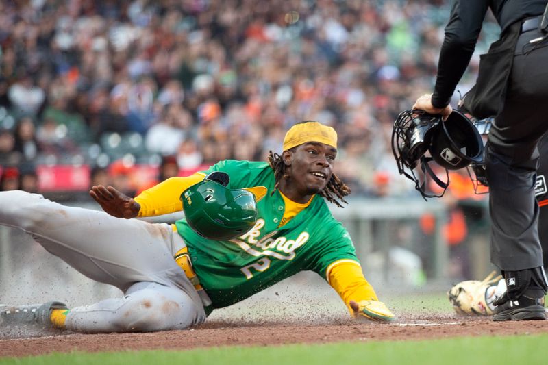 Mar 26, 2024; San Francisco, California, USA; Oakland Athletics right fielder Lawrence Butler (2) slides safely home past San Francisco Giants catcher Patrick Bailey (14) on a sacrifice fly by Esteury Ruiz during the fourth inning at Oracle Park. Mandatory Credit: D. Ross Cameron-USA TODAY Sports