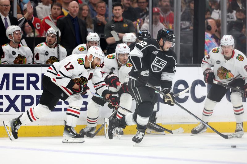 Mar 19, 2024; Los Angeles, California, USA;  Los Angeles Kings left wing Kevin Fiala (22) chases the puck against Chicago Blackhawks left wing Nick Foligno (17) during the third period at Crypto.com Arena. Mandatory Credit: Kiyoshi Mio-USA TODAY Sports