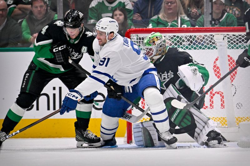 Dec 21, 2025; Dallas, Texas, USA; Dallas Stars defenseman Miro Heiskanen (4) and Toronto Maple Leafs center John Tavares (91) battle for the puck in front of goaltender Jake Oettinger (29) during the second period at the American Airlines Center. Mandatory Credit: Jerome Miron-Imagn Images
