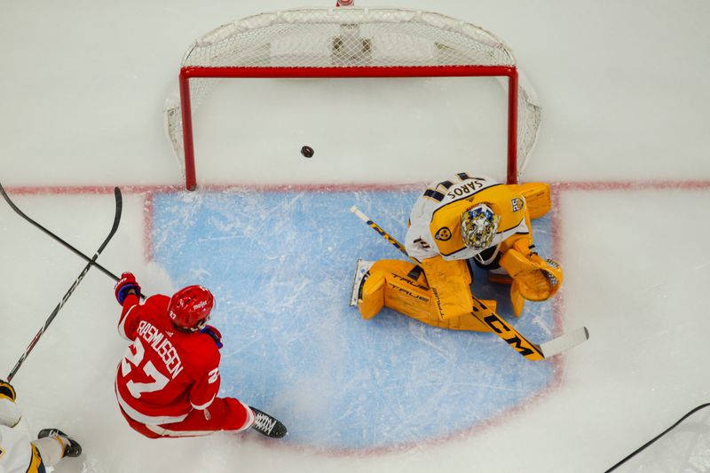 Dec 29, 2023; Detroit, Michigan, USA; The pucks slips past Nashville Predators goaltender Juuse Saros (74) during the game between the Detroit Red Wings and the Nashville Predators at Little Caesars Arena. Mandatory Credit: Brian Bradshaw Sevald-USA TODAY Sports