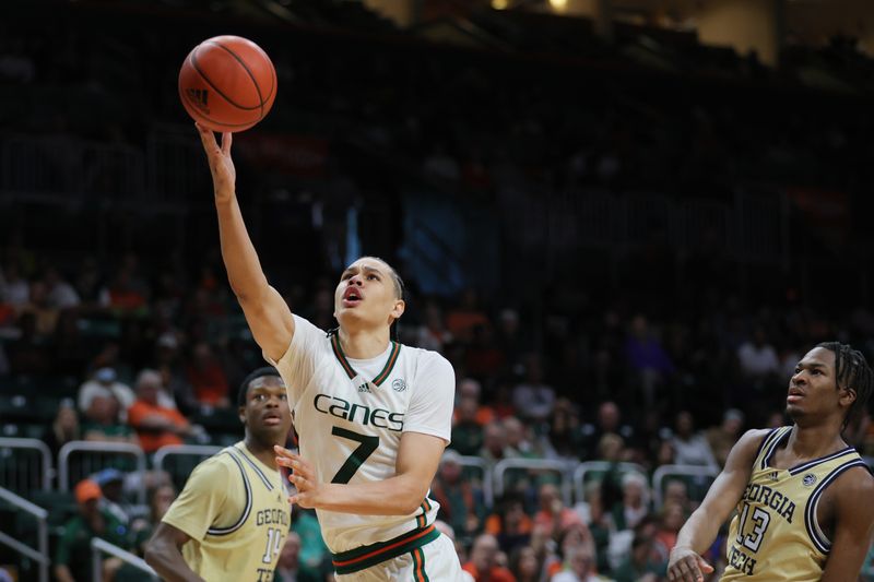 Feb 24, 2024; Coral Gables, Florida, USA; Miami Hurricanes guard Kyshawn George (7) drives to the basket past Georgia Tech Yellow Jackets guard Miles Kelly (13) during the second half at Watsco Center. Mandatory Credit: Sam Navarro-USA TODAY Sports