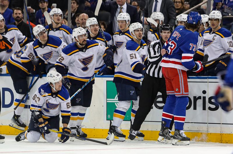 Nov 25, 2024; New York, New York, USA; New York Rangers center Matt Rempe (73) is pulled away by a linesman after a hit on St. Louis Blues left wing Jake Neighbours (63) that was called for roughing during the third period at Madison Square Garden. Mandatory Credit: Danny Wild-Imagn Images