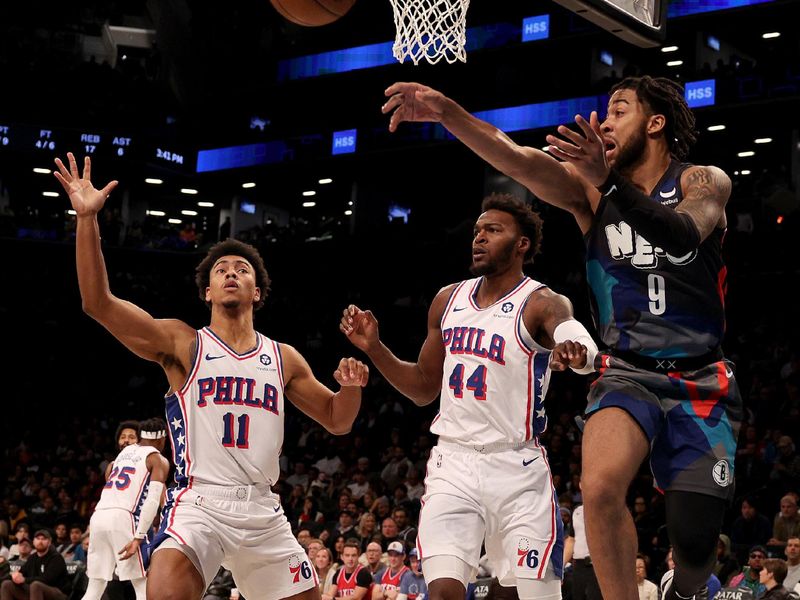 NEW YORK, NEW YORK - NOVEMBER 19:  Trendon Watford #9 of the Brooklyn Nets passes as Jaden Springer #11 and Paul Reed #44 of the Philadelphia 76ers defend in the first halfat Barclays Center on November 19, 2023 in the Brooklyn borough of New York City. NOTE TO USER: User expressly acknowledges and agrees that, by downloading and or using this photograph, User is consenting to the terms and conditions of the Getty Images License Agreement. (Photo by Elsa/Getty Images)