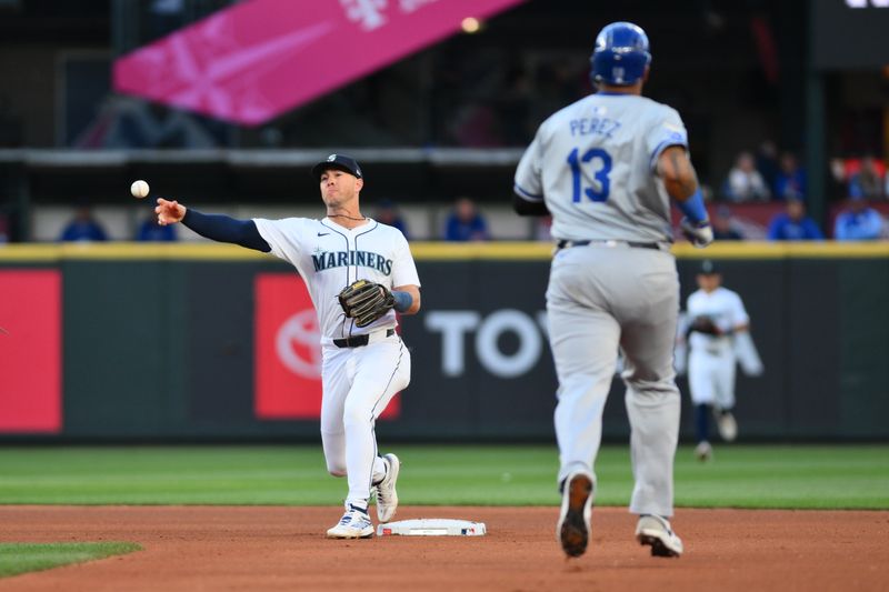 May 14, 2024; Seattle, Washington, USA; Seattle Mariners shortstop Dylan Moore (25) throws to first base to complete a double play against the Kansas City Royals during the fifth inning at T-Mobile Park. Mandatory Credit: Steven Bisig-USA TODAY Sports