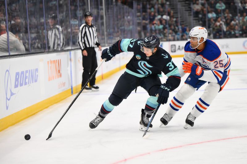 Oct 2, 2024; Seattle, Washington, USA; Seattle Kraken center Yanni Gourde (37) advances the puck while defended by Edmonton Oilers defenseman Darnell Nurse (25)  during the third period at Climate Pledge Arena. Mandatory Credit: Steven Bisig-Imagn Images