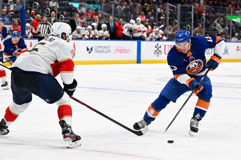 Oct 26, 2024; Elmont, New York, USA;  New York Islanders center Mathew Barzal (13) skates with the puck defended by Florida Panthers defenseman Aaron Ekblad (5) during the second period at UBS Arena. Mandatory Credit: Dennis Schneidler-Imagn Images