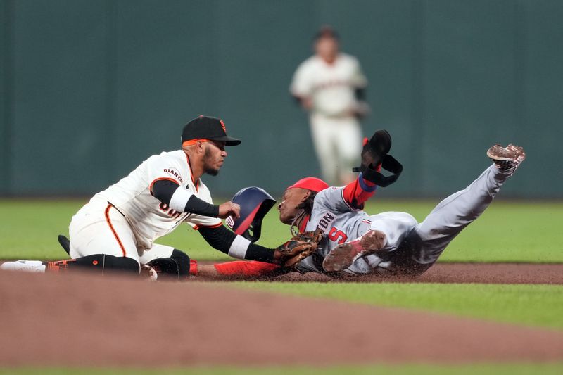 Apr 9, 2024; San Francisco, California, USA; San Francisco Giants second baseman Thairo Estrada (left) tags out Washington Nationals shortstop CJ Abrams (5) on a steal attempt during the fifth inning at Oracle Park. Mandatory Credit: Darren Yamashita-USA TODAY Sports