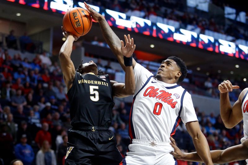 Jan 13, 2024; Oxford, Mississippi, USA; Mississippi Rebels guard Brandon Murray (0) blocks a shot by Vanderbilt Commodores guard Ezra Manjon (5) during the first half at The Sandy and John Black Pavilion at Ole Miss. Mandatory Credit: Petre Thomas-USA TODAY Sports