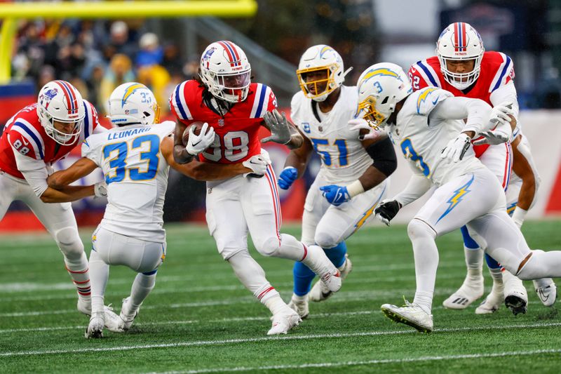 New England Patriots running back Rhamondre Stevenson (38) escapes the grasp of Los Angeles Chargers cornerback Deane Leonard (33) and evades Los Angeles Chargers cornerback Deane Leonard (33) during the first half of an NFL football game on Sunday, Dec. 3, 2023, in Foxborough, Mass. (AP Photo/Greg M. Cooper)