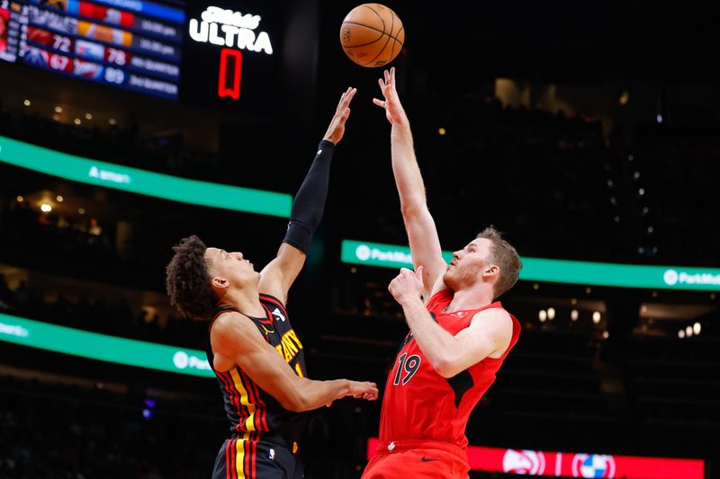 ATLANTA, GEORGIA - FEBRUARY 23: Jakob Poeltl #19 of the Toronto Raptors shoots against Jalen Johnson #1 of the Atlanta Hawks during the fourth quarter at State Farm Arena on February 23, 2024 in Atlanta, Georgia. NOTE TO USER: User expressly acknowledges and agrees that, by downloading and or using this photograph, User is consenting to the terms and conditions of the Getty Images License Agreement. (Photo by Todd Kirkland/Getty Images)