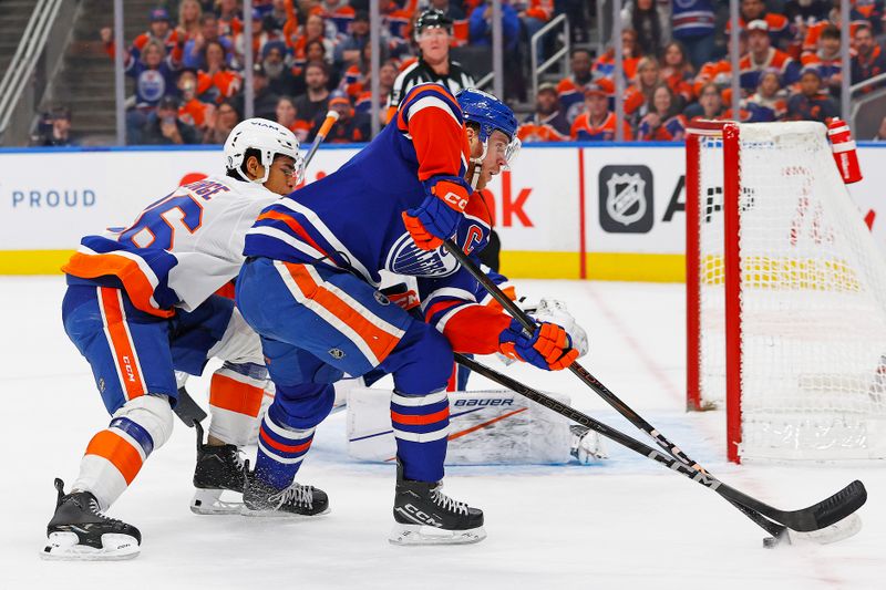 Nov 12, 2024; Edmonton, Alberta, CAN; New York Islanders defensemen Isaiah George (36) knocks the puck away from Edmonton Oilers forward Connor McDavid (97) during the third period at Rogers Place. Mandatory Credit: Perry Nelson-Imagn Images