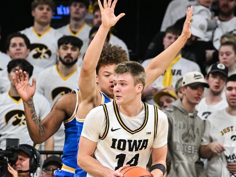 Jan 3, 2026; Iowa City, Iowa, USA; Iowa Hawkeyes guard Bennett Stirtz (14) is defended by UCLA Bruins guard Trent Perry (0) during the first half at Carver-Hawkeye Arena. Mandatory Credit: Jeffrey Becker-Imagn Images