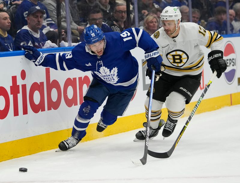 Apr 24, 2024; Toronto, Ontario, CAN; Toronto Maple Leafs forward Calle Jarnkrok (19) and Boston Bruins defenseman Kevin Shattenkirk (12) battle to get to the puck during the first period of game three of the first round of the 2024 Stanley Cup Playoffs at Scotiabank Arena. Mandatory Credit: John E. Sokolowski-USA TODAY Sports