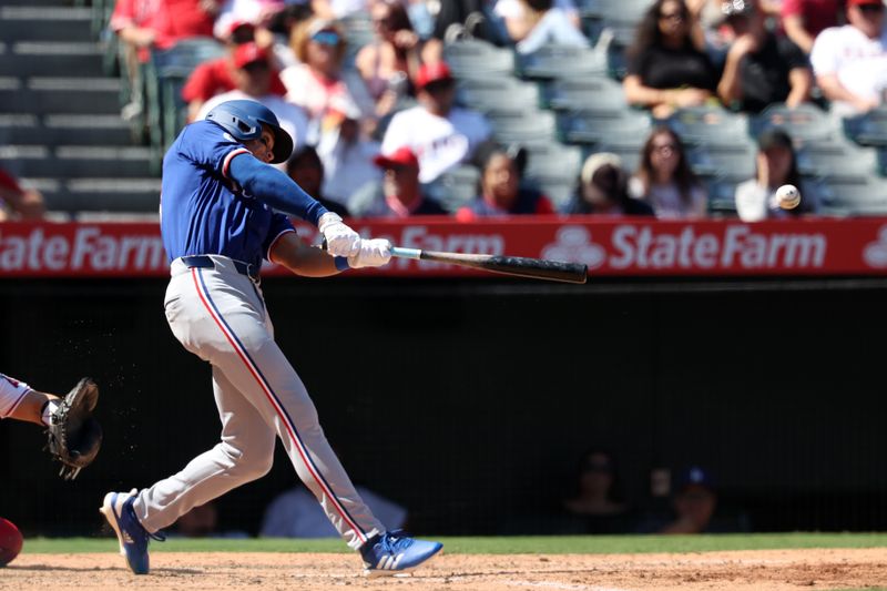 Sep 29, 2024; Anaheim, California, USA;  Texas Rangers designated hitter Dustin Harris (38) hits an RBI double, his first MLB hit, during the seventh inning against the Los Angeles Angels at Angel Stadium. Mandatory Credit: Kiyoshi Mio-Imagn Images