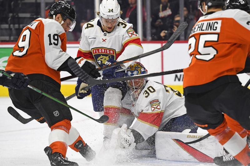 Dec 5, 2024; Philadelphia, Pennsylvania, USA; Florida Panthers goaltender Spencer Knight (30) covers the puck with help from defenseman Adam Boqvist (34) against Philadelphia Flyers right wing Garnet Hathaway (19) during the first period at Wells Fargo Center. Mandatory Credit: Eric Hartline-Imagn Images