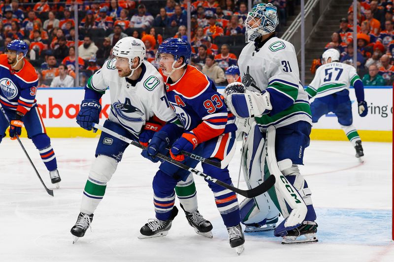 May 12, 2024; Edmonton, Alberta, CAN; Edmonton Oilers forward Ryan Nugent-Hopkins (93) battles with Vancouver Canucks defensemen Carson Soucy (7) in front of  goaltender Arturs Silovs (31) during the third period in game three of the second round of the 2024 Stanley Cup Playoffs at Rogers Place. Mandatory Credit: Perry Nelson-USA TODAY Sports