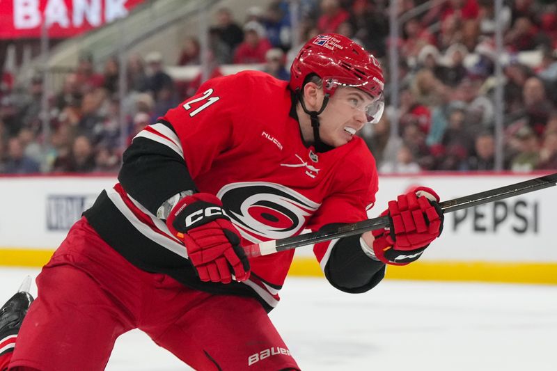 Dec 29, 2025; Raleigh, North Carolina, USA;  Carolina Hurricanes defenseman Alexander Nikishin (21) takes a shot against the New York Rangers during the first period at Lenovo Center. Mandatory Credit: James Guillory-Imagn Images