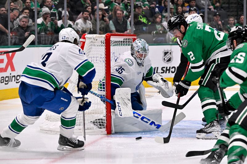 Jan 31, 2025; Dallas, Texas, USA; Vancouver Canucks goaltender Thatcher Demko (35) stops a shot by Dallas Stars defenseman Brendan Smith (2) during the second period at the American Airlines Center. Mandatory Credit: Jerome Miron-Imagn Images