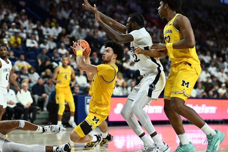 Jan 7, 2024; Philadelphia, Pennsylvania, USA; Michigan Wolverines forward Olivier Nkamhoua (13) falls against Penn State Nittany Lions forward Qudus Wahab (22) in the second half at The Palestra. Mandatory Credit: Kyle Ross-USA TODAY Sports