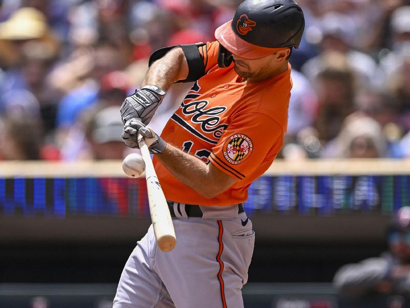 Jul 8, 2023; Minneapolis, Minnesota, USA;  Baltimore Orioles infielder Adam Frazier (12) hits an RBI single against the Minnesota Twins during the second inning at Target Field. Mandatory Credit: Nick Wosika-USA TODAY Sports