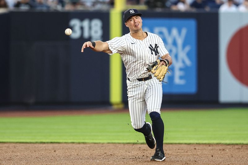 May 22, 2024; Bronx, New York, USA;  New York Yankees shortstop Anthony Volpe (11) throws a runner out at first base in the third inning against the Seattle Mariners at Yankee Stadium. Mandatory Credit: Wendell Cruz-USA TODAY Sports