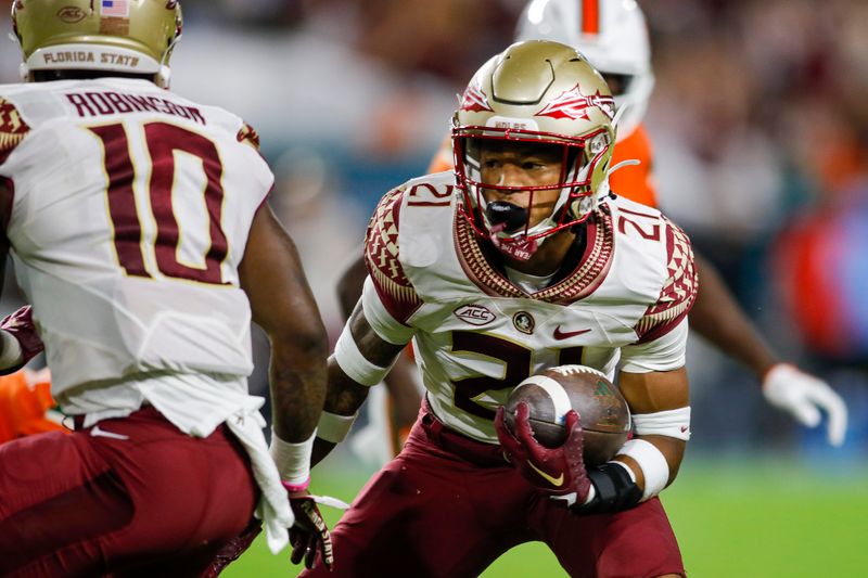 Nov 5, 2022; Miami Gardens, Florida, USA; Florida State Seminoles defensive back Greedy Vance (21) runs with the football after intercepting a pass during the second quarter against the Miami Hurricanes at Hard Rock Stadium. Mandatory Credit: Sam Navarro-USA TODAY Sports