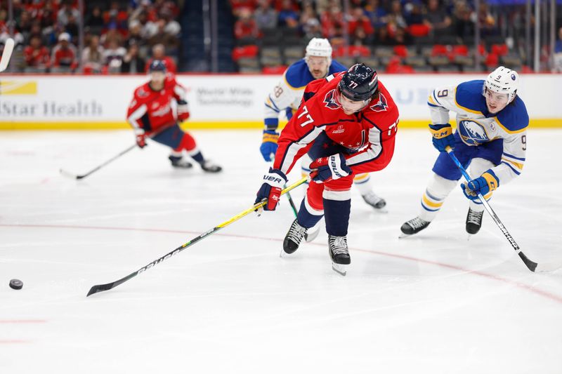 Nov 22, 2023; Washington, District of Columbia, USA; Washington Capitals right wing T.J. Oshie (77) reaches for the puck in front of Buffalo Sabres left wing Zach Benson (9) in the second period at Capital One Arena. Mandatory Credit: Geoff Burke-USA TODAY Sports