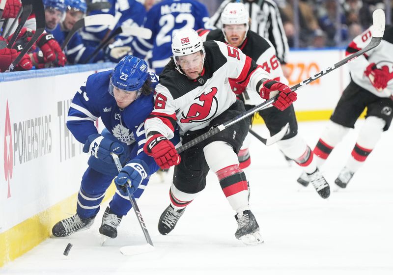 Mar 26, 2024; Toronto, Ontario, CAN; Toronto Maple Leafs left wing Matthew Knies (23) battles for the puck with New Jersey Devils left wing Erik Haula (56) during the first period at Scotiabank Arena. Mandatory Credit: Nick Turchiaro-USA TODAY Sports