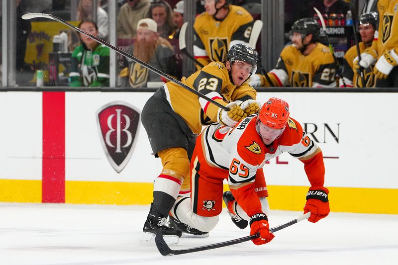 Nov 8, 2025; Las Vegas, Nevada, USA; Vegas Golden Knights left wing Cole Reinhardt (23) checks Anaheim Ducks defenseman Jacob Trouba (65) during the second period at T-Mobile Arena. Mandatory Credit: Stephen R. Sylvanie-Imagn Images