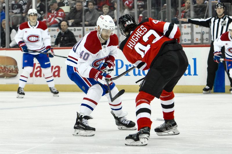 Feb 24, 2024; Newark, New Jersey, USA; Montreal Canadiens right wing Joel Armia (40) moves the puck as New Jersey Devils defenseman Luke Hughes (43) defends during the first period at Prudential Center. Mandatory Credit: John Jones-USA TODAY Sports