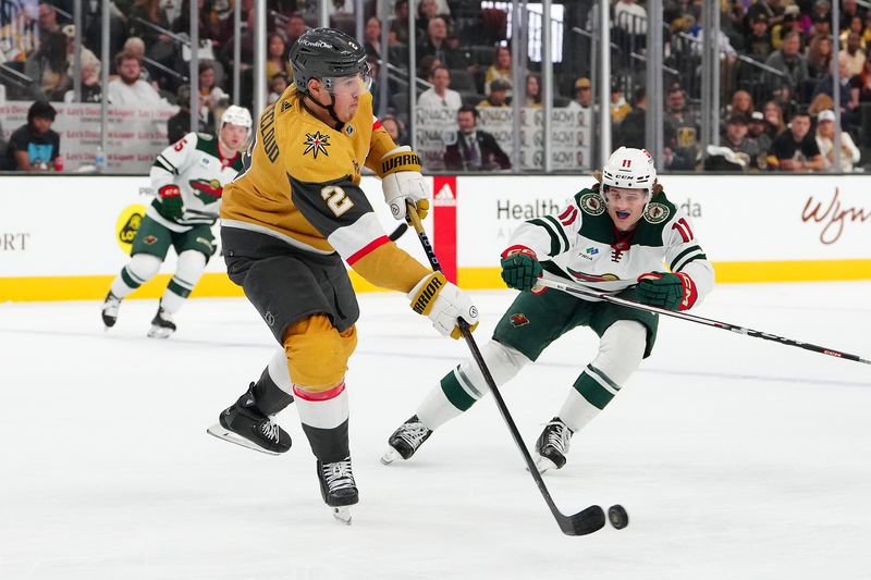 Apr 12, 2024; Las Vegas, Nevada, USA; Vegas Golden Knights defenseman Zach Whitecloud (2) clears the puck away from Minnesota Wild left wing Adam Beckman (11) during the first period at T-Mobile Arena. Mandatory Credit: Stephen R. Sylvanie-USA TODAY Sports