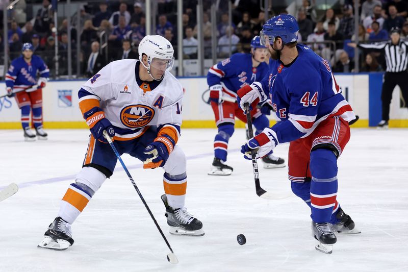 Mar 3, 2025; New York, New York, USA; New York Islanders center Bo Horvat (14) fights for the puck against New York Rangers defenseman Calvin de Haan (44) during the second period at Madison Square Garden. Mandatory Credit: Brad Penner-Imagn Images