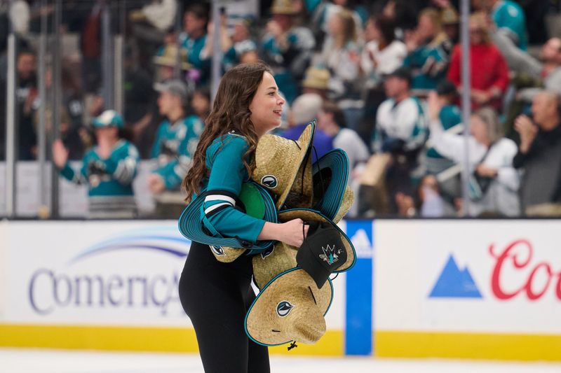 Apr 6, 2024; San Jose, California, USA; A worker carries hats that were tossed onto the ice after San Jose Sharks left wing William Eklund (72) (not pictured) scored the third goal of his hat trick to defeat the St. Louis Blues during the overtime period at SAP Center at San Jose. Mandatory Credit: Robert Edwards-USA TODAY Sports