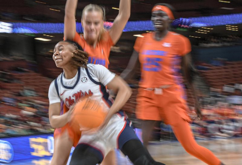 March 8, 2024; Greenville, S.C.; Ole Miss guard Zakiya Stephenson (21) drives to the basket near Florida forward Faith Dut (25) during the second quarter of the SEC Women's Basketball Tournament game at the Bon Secours Wellness Arena in Greenville, S.C. Friday, March 8, 2024. . Mandatory Credit: Ken Ruinard -USA TODAY NETWORK