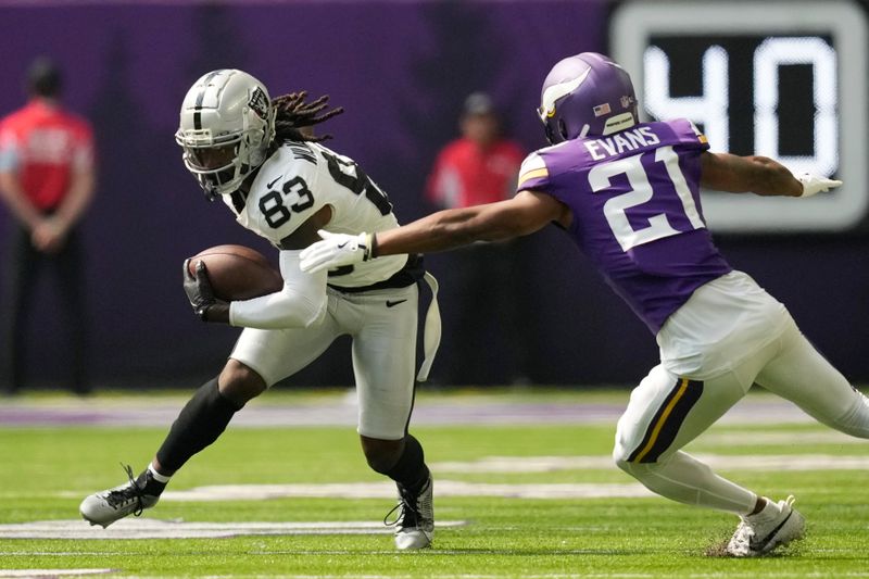 Las Vegas Raiders wide receiver Kristian Wilkerson (83) makes a catch in front of Minnesota Vikings cornerback Akayleb Evans (21) during the first half of an NFL football game Saturday, Aug. 10, 2024, in Minneapolis. (AP Photo/Charlie Neibergall)