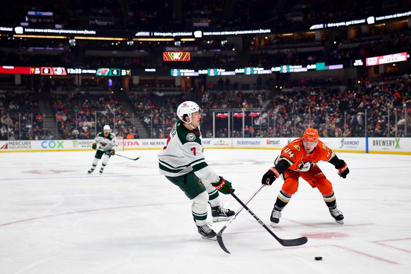 Dec 6, 2024; Anaheim, California, USA; Anaheim Ducks left wing Ross Johnston (44) plays for the puck against Minnesota Wild defenseman Brock Faber (7) during the third period at Honda Center. Mandatory Credit: Gary A. Vasquez-Imagn Images