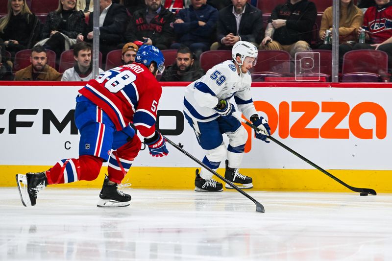 Jan 21, 2025; Montreal, Quebec, CAN; Tampa Bay Lightning center Jake Guentzel (59) plays the puck against Montreal Canadiens defenseman David Savard (58) during the second period at Bell Centre. Mandatory Credit: David Kirouac-Imagn Images