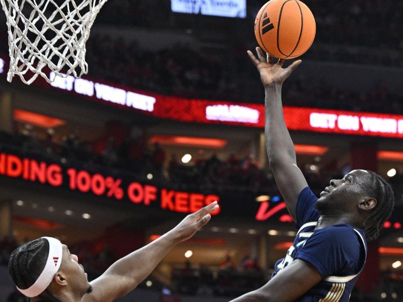 Feb 21, 2026; Louisville, Kentucky, USA;  Georgia Tech Yellow Jackets forward Baye Ndongo (11) shoots against Louisville Cardinals guard Adrian Wooley (14) and guard Ryan Conwell (3) during the first half at KFC Yum! Center. Mandatory Credit: Jamie Rhodes-Imagn Images