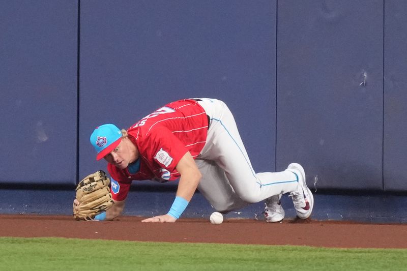 Sep 7, 2024; Miami, Florida, USA;  Miami Marlins center fielder Kyle Stowers (28) collides with the wall while trying to catch a fly ball in the fourth inning against the Philadelphia Phillies at loanDepot Park. Mandatory Credit: Jim Rassol-Imagn Images