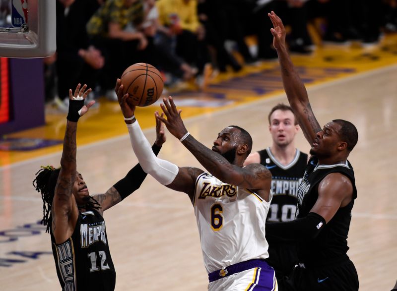 LOS ANGELES, CA - APRIL 22: LeBron James #6 of the Los Angeles Lakers scores a basket against Ja Morant #12  and Xavier Tillman #2 of the Memphis Grizzlies during the second half of Round 1 Game 3 of the 2023 NBA Playoffs at Crypto.com Arena on April 22, 2023 in Los Angeles, California. NOTE TO USER: User expressly acknowledges and agrees that, by downloading and or using this photograph, User is consenting to the terms and conditions of the Getty Images License Agreement. (Photo by Kevork Djansezian/Getty Images)