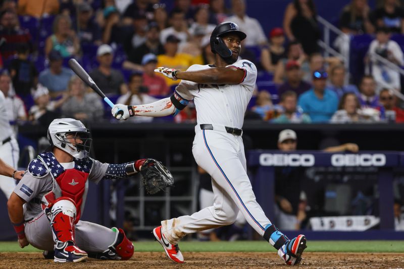 Jul 4, 2024; Miami, Florida, USA; Miami Marlins right fielder Jesus Sanchez (12) hits a double against the Boston Red Sox during the ninth inning at loanDepot Park. Mandatory Credit: Sam Navarro-USA TODAY Sports