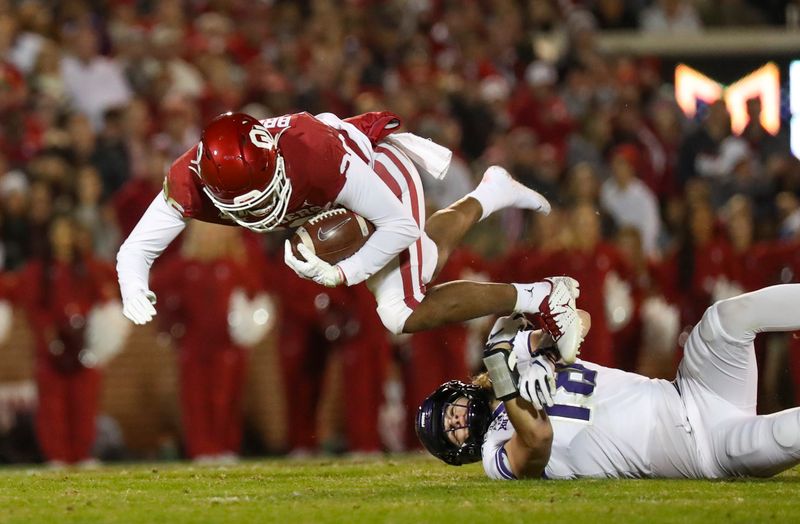 Nov 23, 2019; Norman, OK, USA; Oklahoma Sooners running back Kennedy Brooks (26) leaps over TCU Horned Frogs linebacker Ben Wilson (18) during the first quarter at Gaylord Family - Oklahoma Memorial Stadium. Mandatory Credit: Kevin Jairaj-USA TODAY Sports