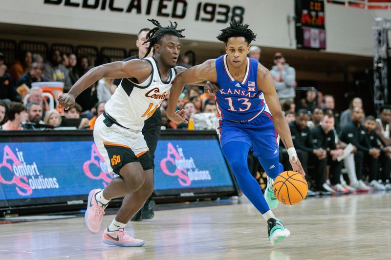 Jan 16, 2024; Stillwater, Oklahoma, USA; Kansas Jayhawks guard Charlie McCarthy (13) drives past Oklahoma State Cowboys guard Jamyron Keller (14) during the second half at Gallagher-Iba Arena. Mandatory Credit: William Purnell-USA TODAY Sports