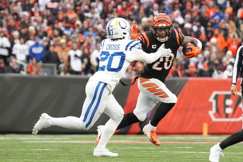 Cincinnati Bengals running back Joe Mixon (28) tries to stiff arm Indianapolis Colts safety Nick Cross (20) as he rushes during an NFL football game, Sunday, Dec. 10, 2023, in Cincinnati, OH. (AP Photo/Peter Joneleit)