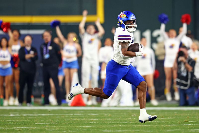 Dec 26, 2023; Phoenix, AZ, USA; Kansas Jayhawks running back Devin Neal (4) runs with the ball during the first quarter against the UNLV Rebels in the Guaranteed Rate Bowl at Chase Field. Mandatory Credit: Mark J. Rebilas-USA TODAY Sports