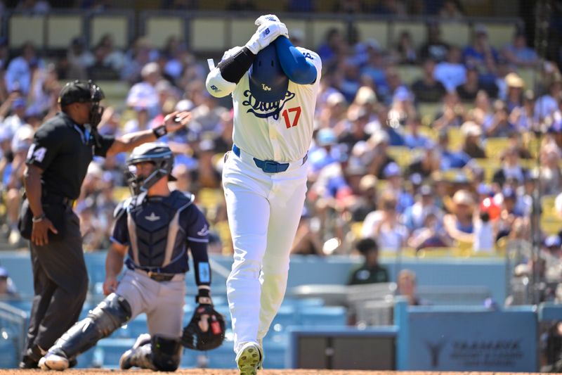 Aug 25, 2024; Los Angeles, California, USA;  Los Angeles Dodgers designated hitter Shohei Ohtani (17) clutches his wrist as he runs to first base after he was hit by a pitch in the eighth inning against the Tampa Bay Rays at Dodger Stadium. Mandatory Credit: Jayne Kamin-Oncea-USA TODAY Sports