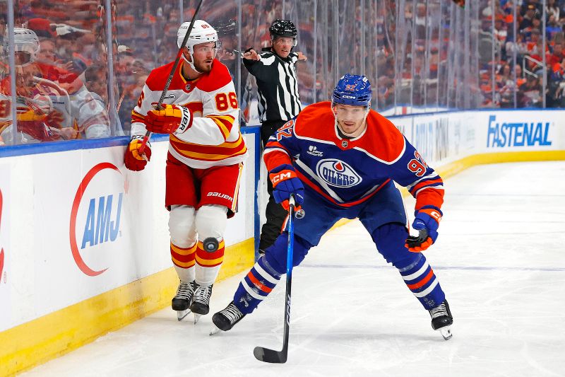 Oct 8, 2025; Edmonton, Alberta, CAN; .Edmonton Oilers forward Vasily Podkolzin (92) and Calgary Flames forward Joel Farabee (86) looks for a loose puck during the second period at Rogers Place. Mandatory Credit: Perry Nelson-Imagn Images